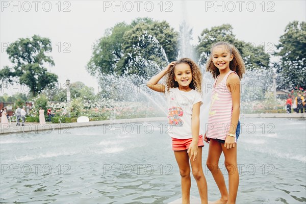 Mixed race sisters smiling in park