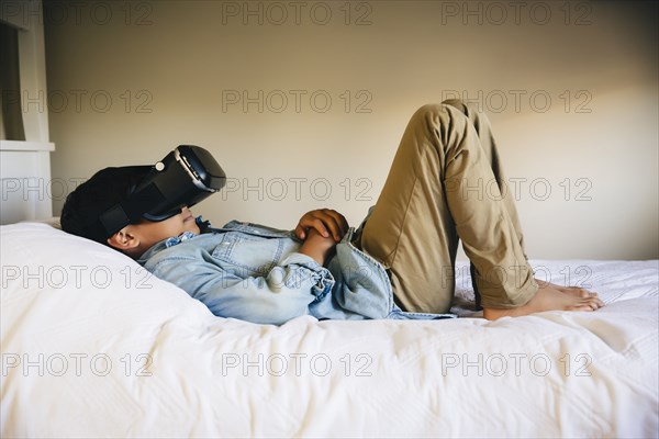 Mixed race boy using virtual reality goggles