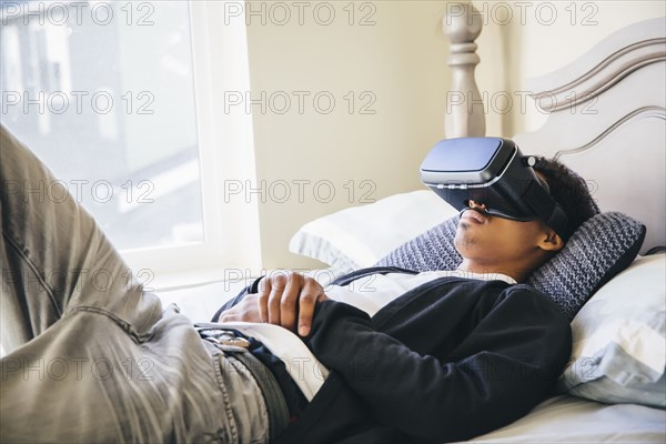 Mixed race man using virtual reality goggles