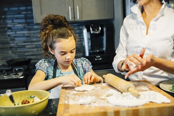 Mother and daughter baking in kitchen