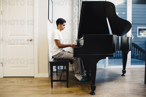 Mixed race boy playing piano