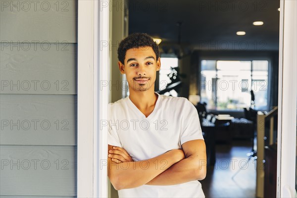 Mixed race man leaning on doorway