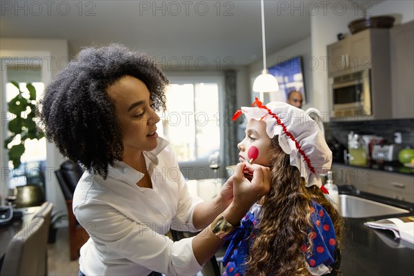 Mother painting face or daughter for Halloween