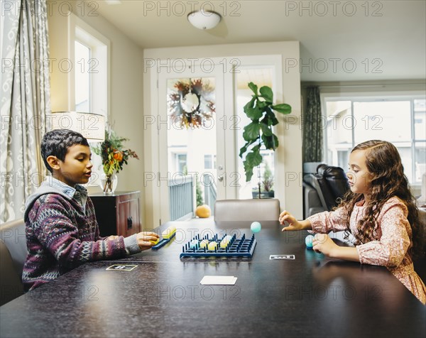 Mixed race siblings playing board game