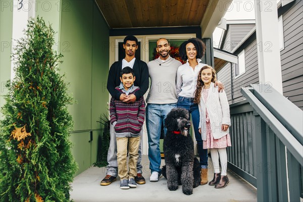 Family and dog smiling on patio