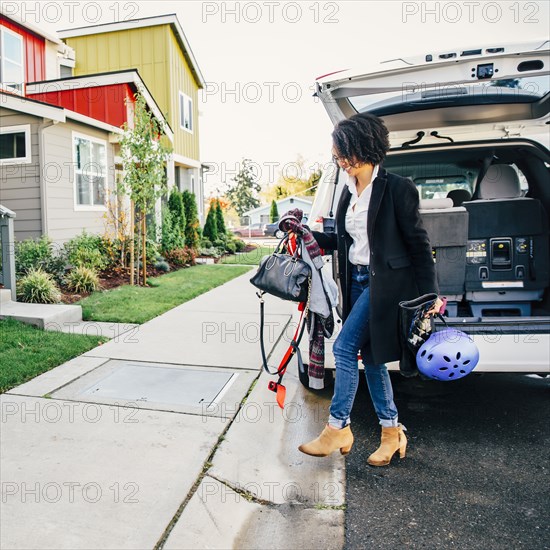 Mixed race woman unpacking car