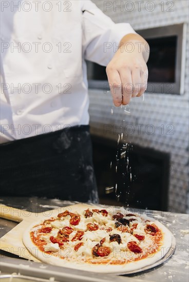 Chef making pizza in restaurant in kitchen