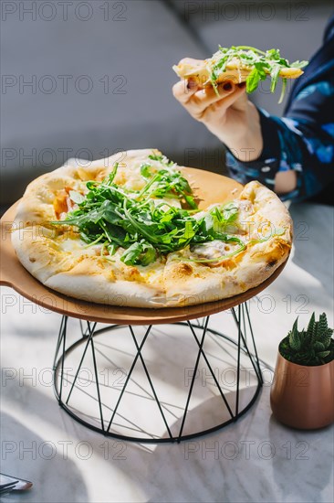 Caucasian woman eating pizza in cafe