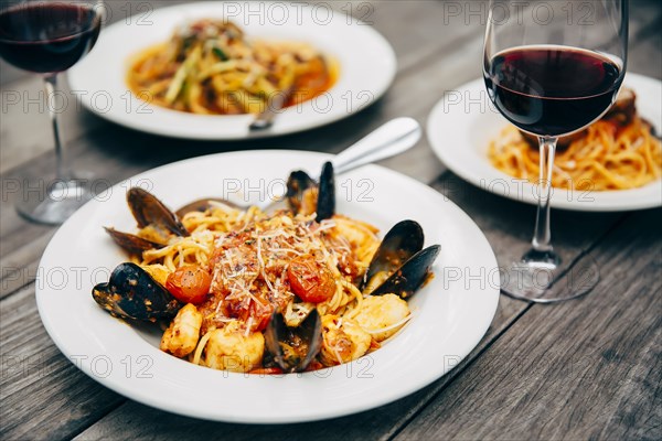 Plates of seafood and pasta with wine glasses