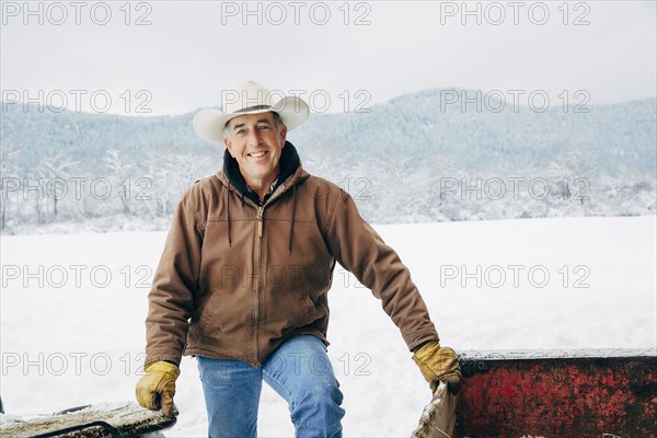 Caucasian farmer smiling in snowy field