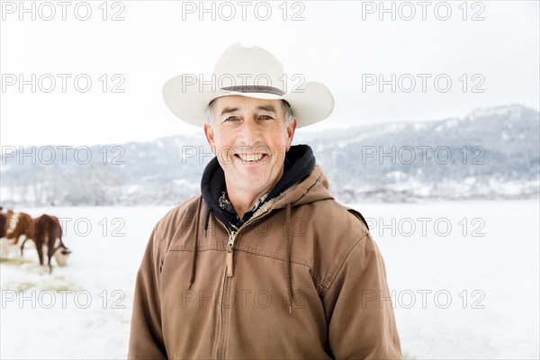 Caucasian farmer smiling in snowy field