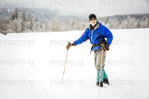 Caucasian woman cross-country skiing in snowy field