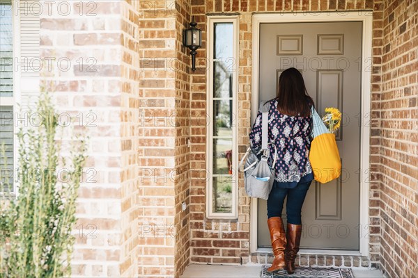 Hispanic woman opening front door