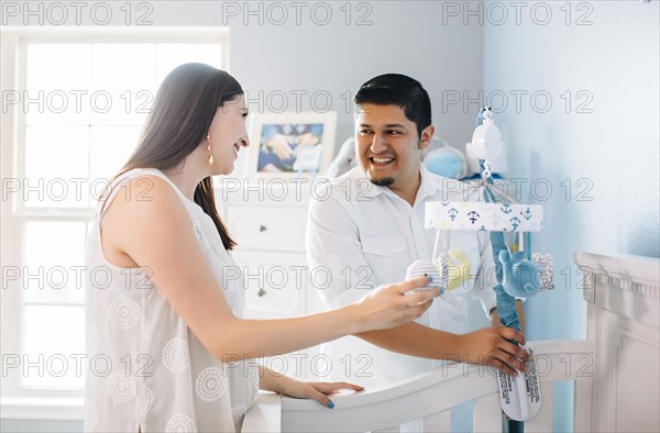 Hispanic couple setting up nursery furniture