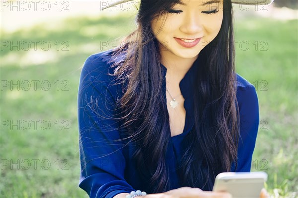 Chinese woman using cell phone outdoors