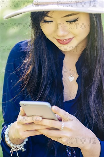 Chinese woman using cell phone outdoors