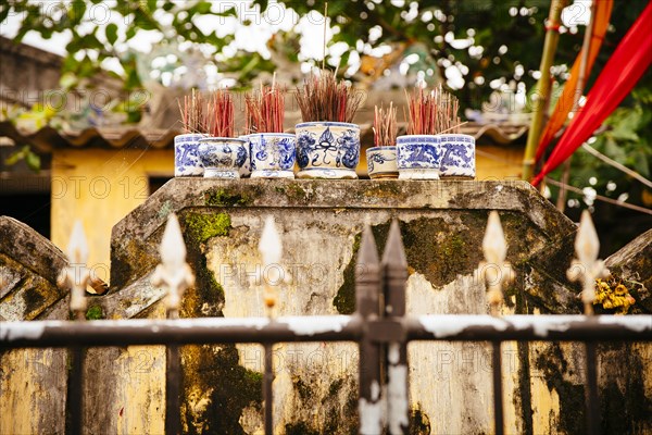 Close up of incense sticks behind fence