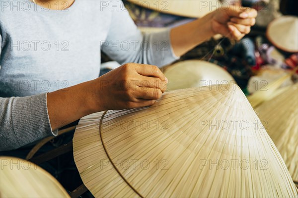 Close up of artisan weaving straw hat