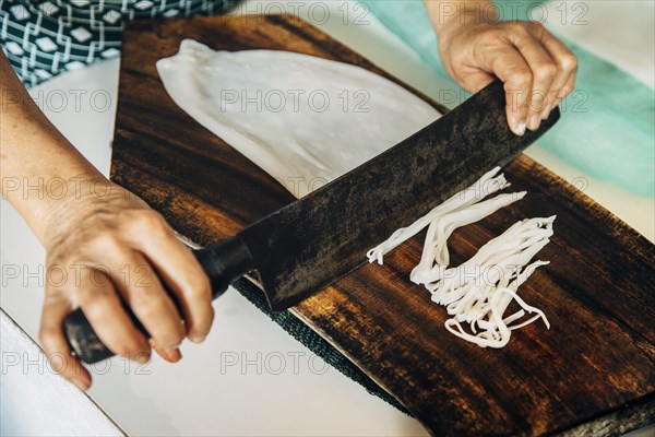 Close up of chef chopping squid on cutting board