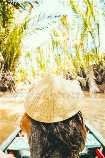 Caucasian woman floating in boat on rural river