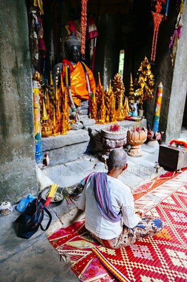 Woman sitting near Buddhist shrine