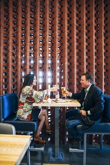 Caucasian couple toasting with cocktails in restaurant