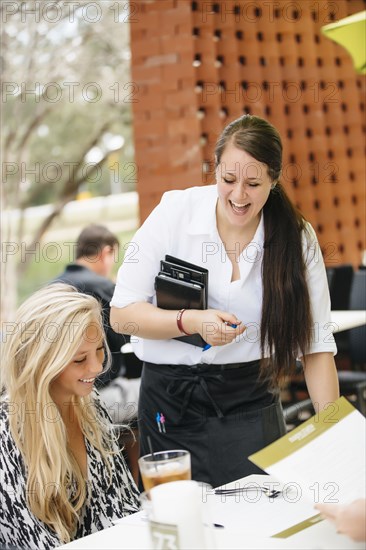 Smiling Caucasian waitress assisting customer