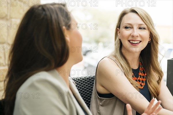 Caucasian women talking at table