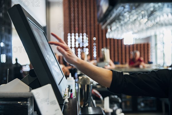 Caucasian  bartender using computer