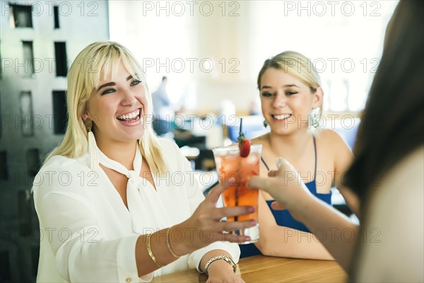 Caucasian bartender serving cocktail to women