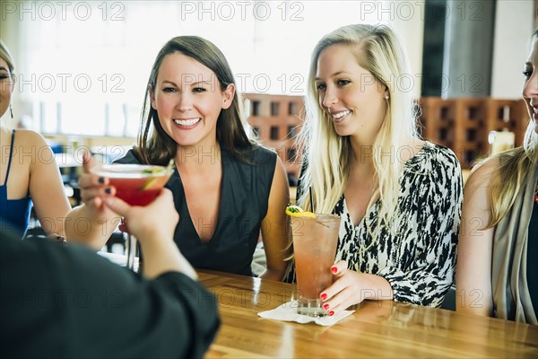 Caucasian bartender serving martini cocktail to customer
