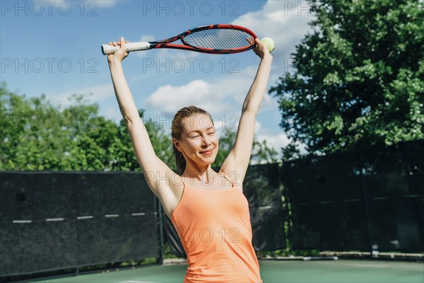 Caucasian woman stretching arms on tennis court