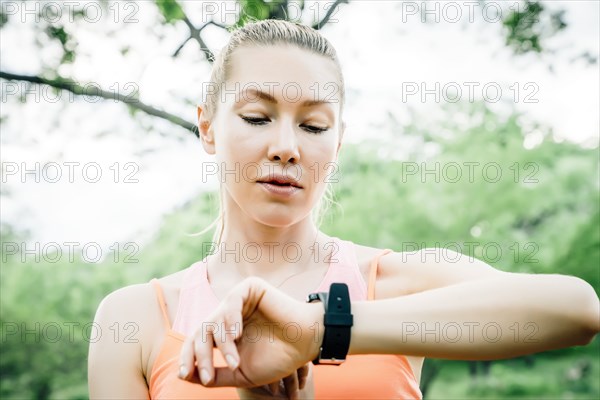 Caucasian woman checking the time on wristwatch outdoors