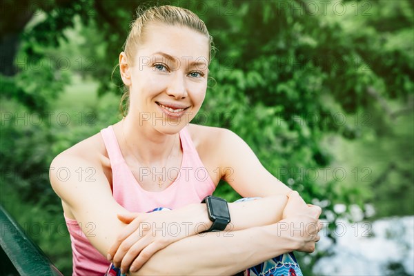 Caucasian woman wearing smart watch sitting outdoors