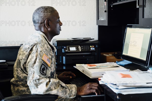 Black soldier using computer