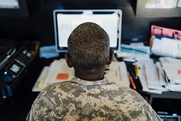 Black soldier using computer