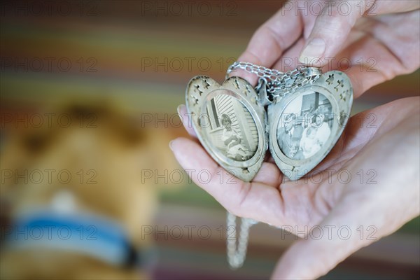 Hands of Caucasian woman showing photographs in cameo