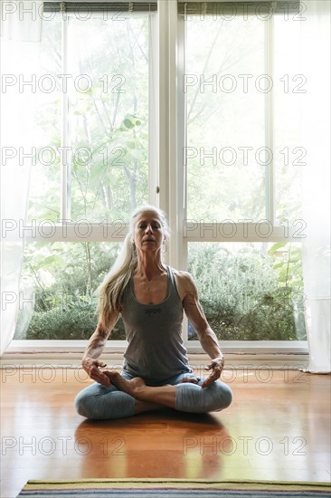 Caucasian woman meditating on floor