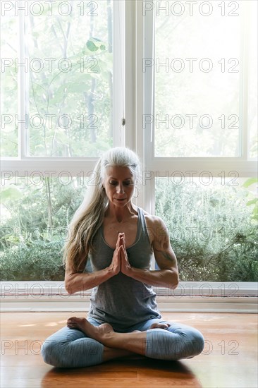 Caucasian woman meditating on floor