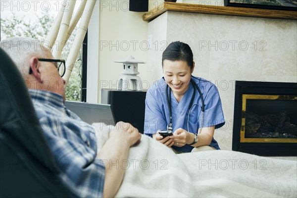 Nurse texting on cell phone near patient