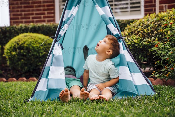 Caucasian brothers in backyard teepee