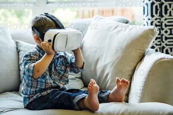 Caucasian boy wearing virtual reality goggles