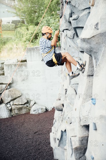 Mixed Race man climbing rock climbing wall