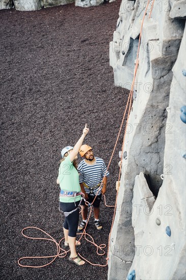 Woman and man looking up at rock climbing wall