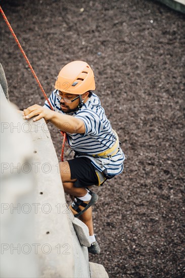 Mixed Race man climbing rock climbing wall