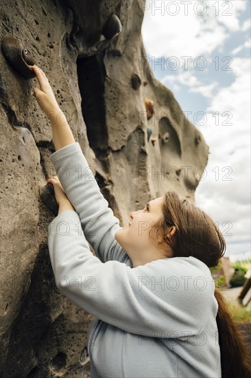 Caucasian woman climbing rock climbing wall