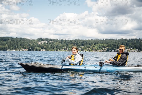 Caucasian man and woman paddling kayak