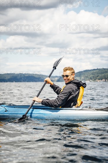 Caucasian man paddling kayak