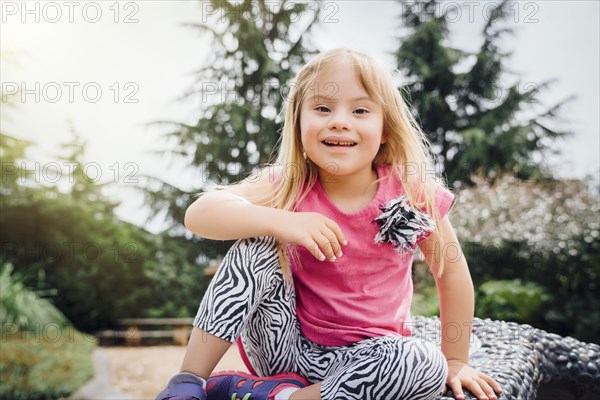 Smiling Mixed Race girl sitting on bench