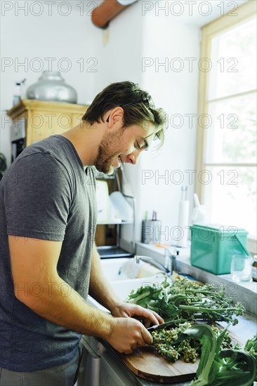 Caucasian man chopping vegetables in kitchen